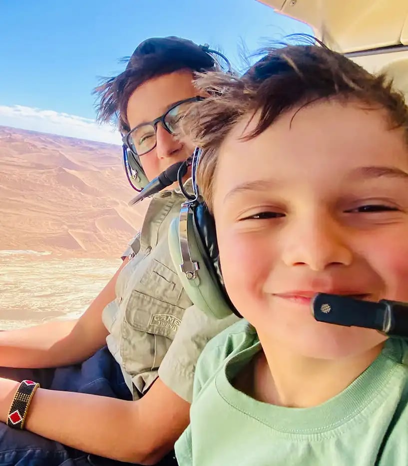 Zwei Jungs in einem Privatflugzeug tragen Headsets und machen ein Selfie