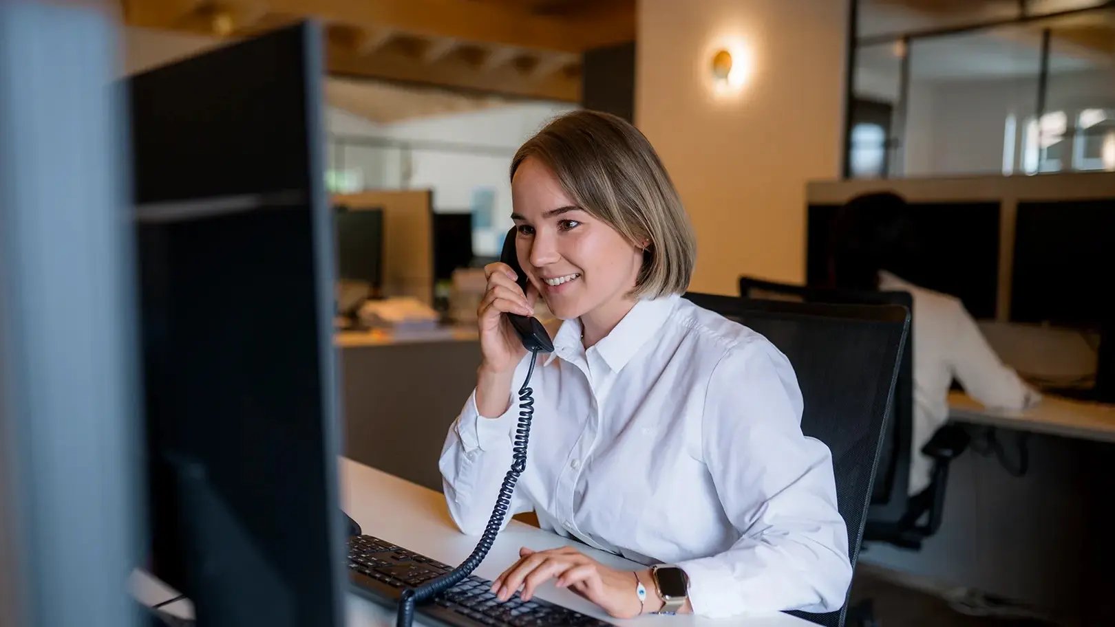 Mitarbeiterin beider Kundenbetreuung am Telefon