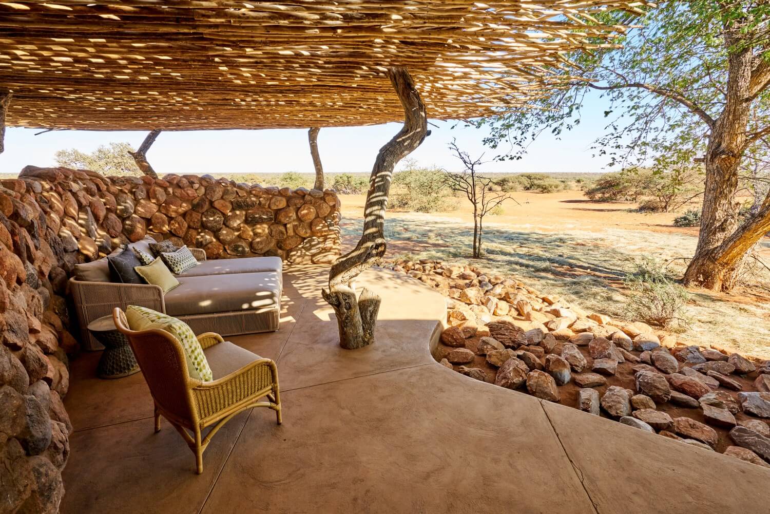 Terrasse einer Safarilodge mit Blick in die Wildnis.