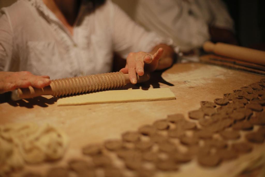 Eine Frau stellt auf traditionelle Weise Orecchiette her.