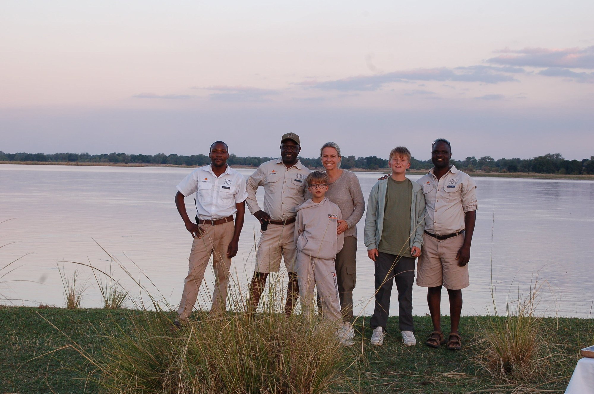 Familienfoto mit dem Safari Guide vor dem Fluss