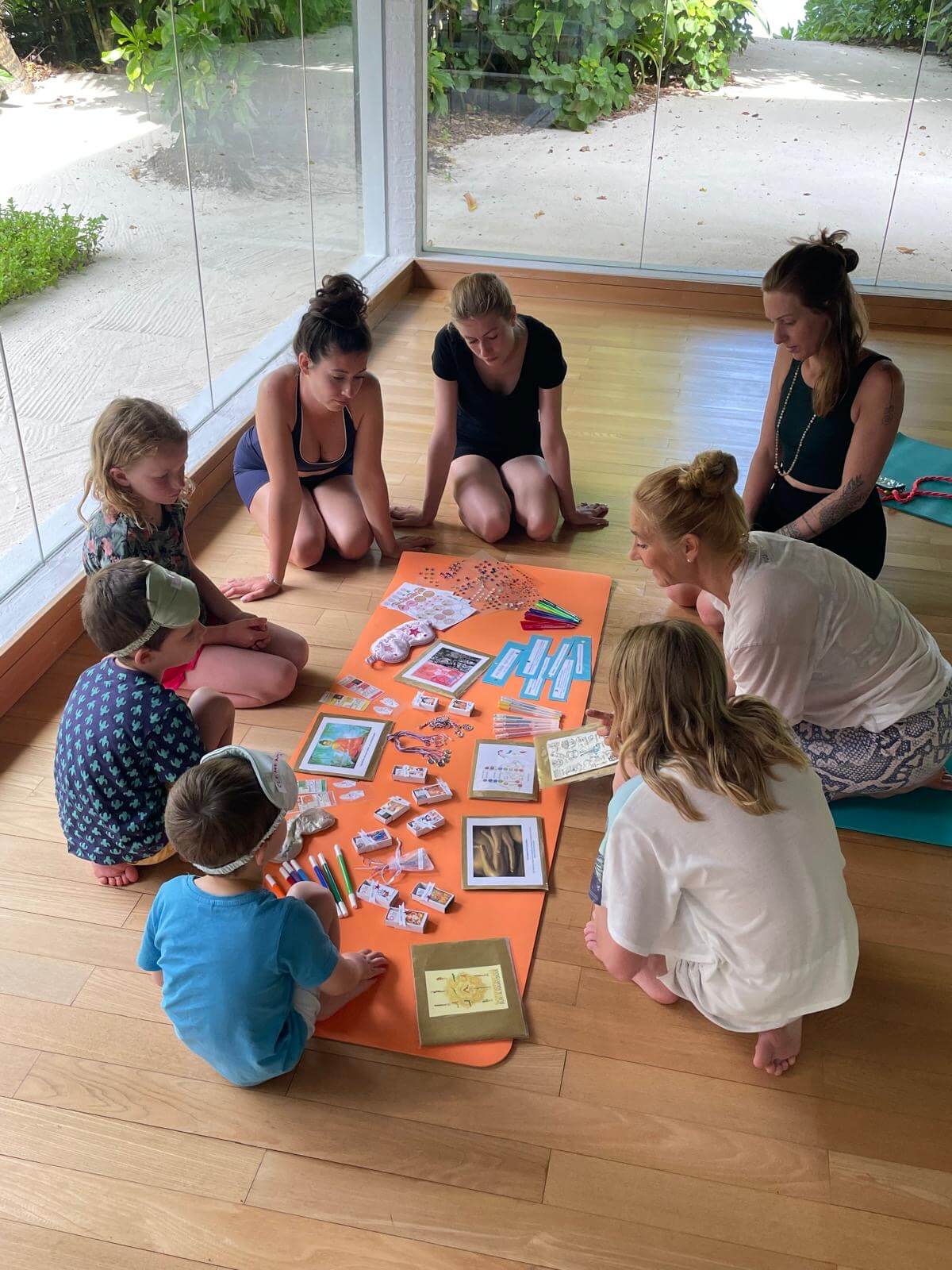 Bei einem Yoga-Workshop auf COMO Maalifushi wird eine Gruppe von Kindern an das Thema in einem Sitzkreis herangeführt.