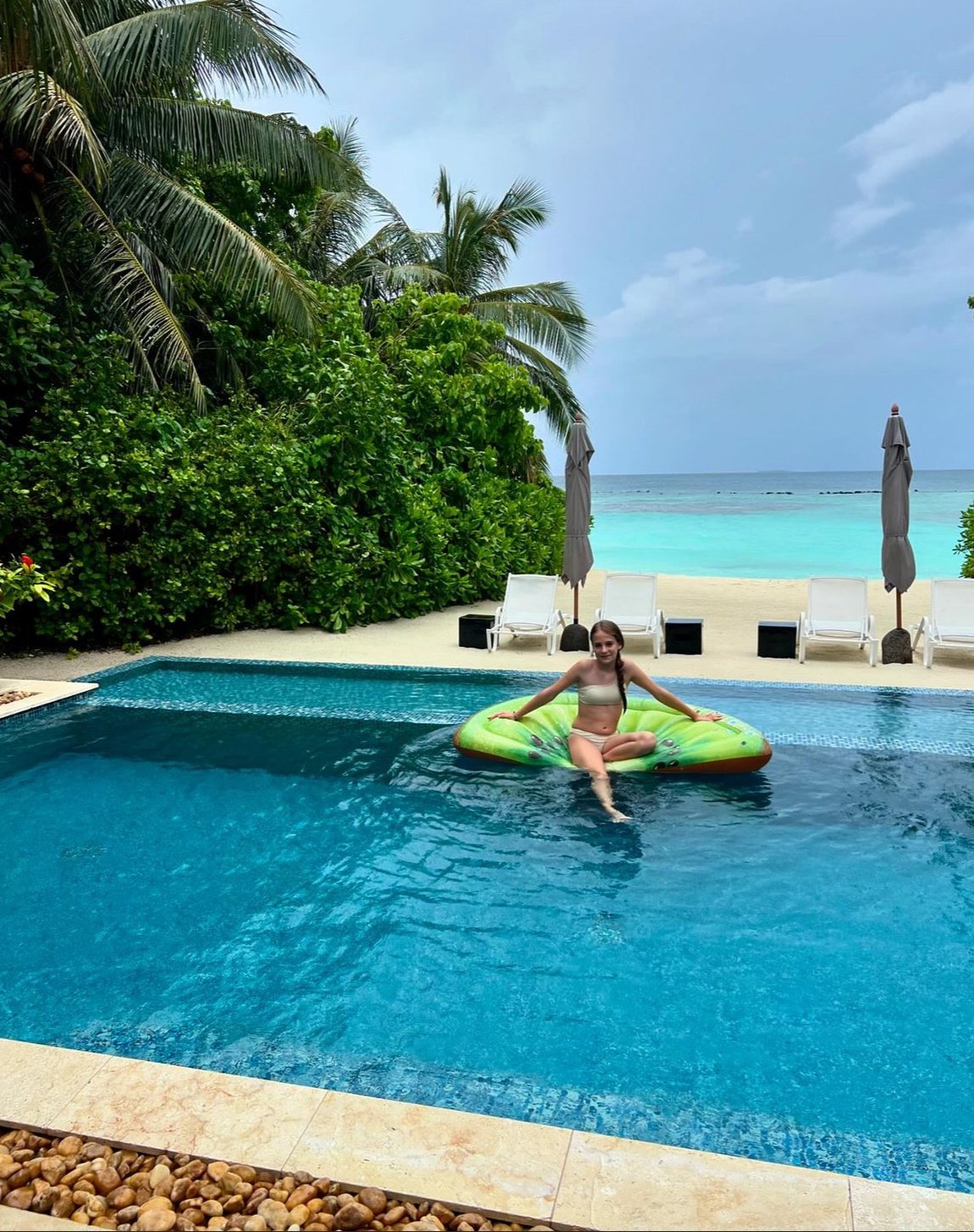 Mädchen schwimmt im Infinity Pool Malediven
