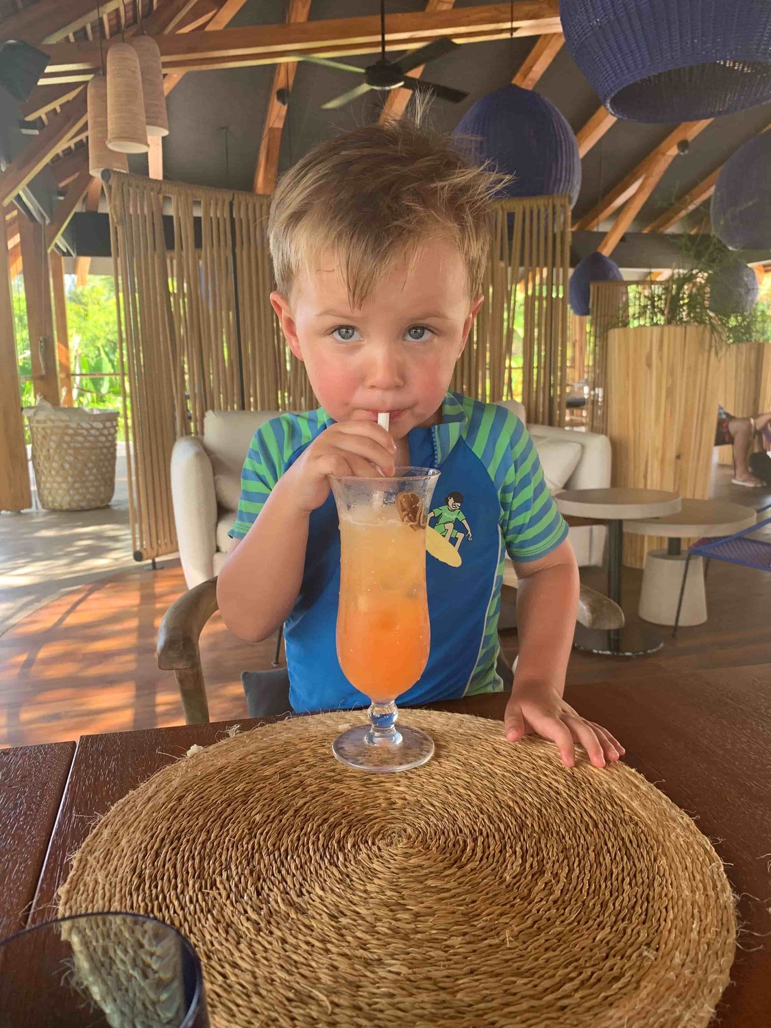Kind trinkt Cocktail an der Strandbar