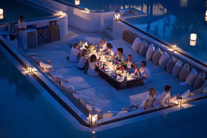 Eine große Familie sitzt in einem luxuriösen Ambiente beim Dinner auf den Malediven.