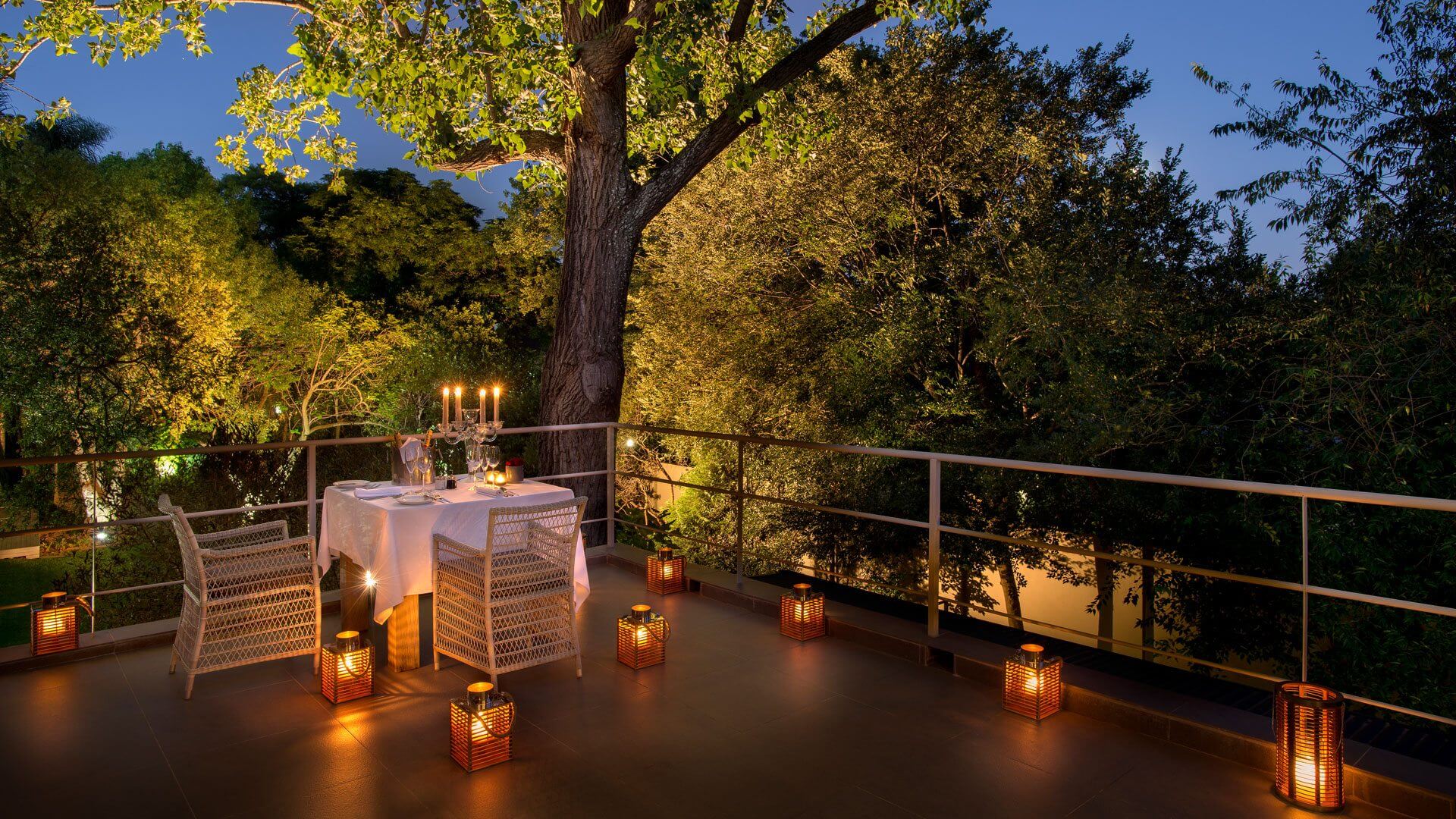 Romantisches privates Dinner auf einer Terrasse bei Laternenlicht.