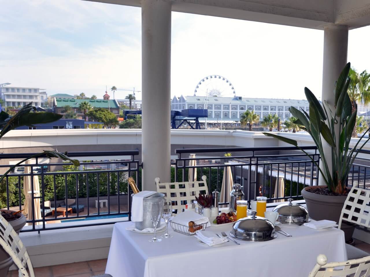 Auf einem Balkon steht ein gedeckter Tisch, es gibt eine Aussicht auf die V&A Waterfront.