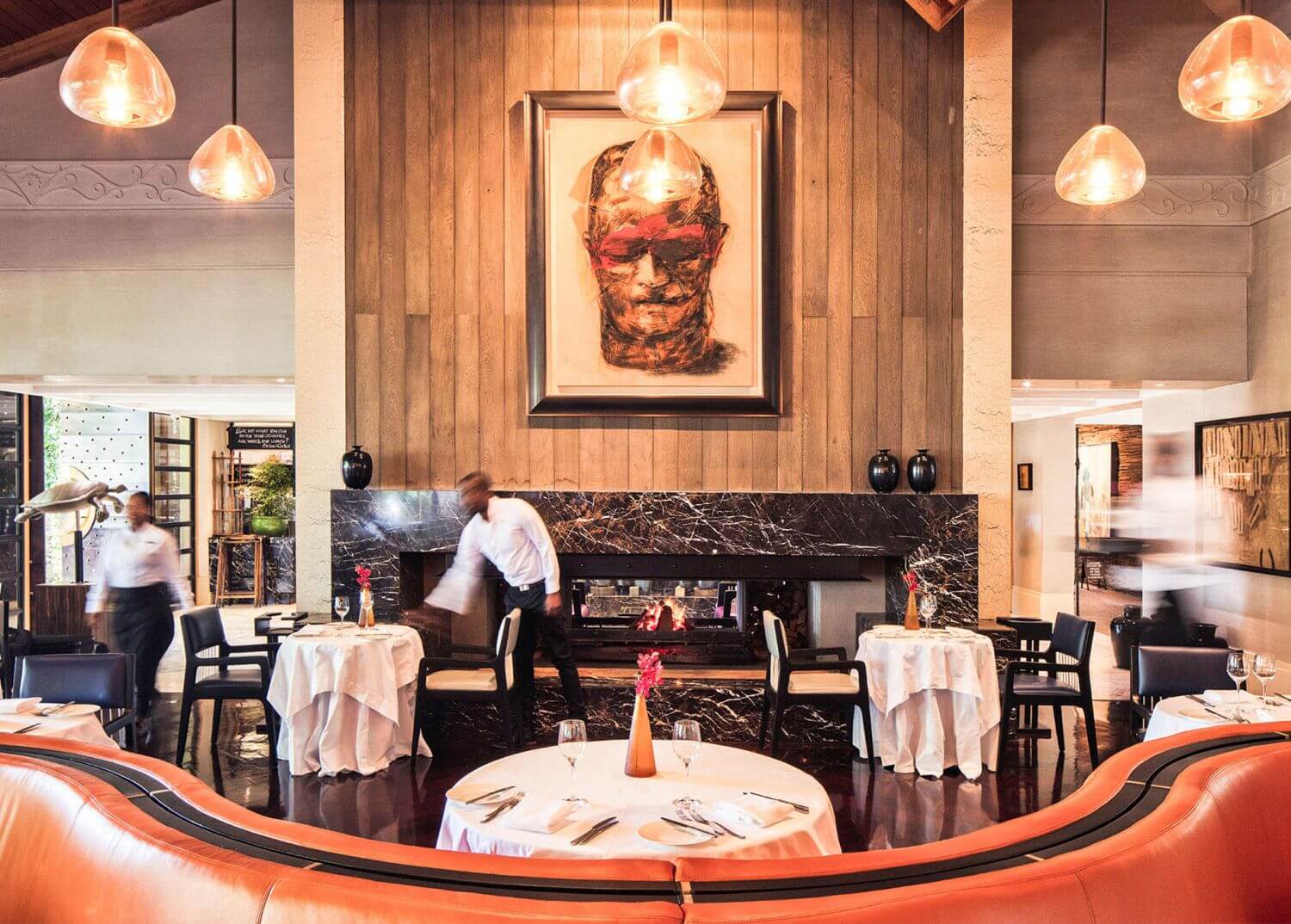 Ein Kellner deckt in einem Restaurant die Tische ein.