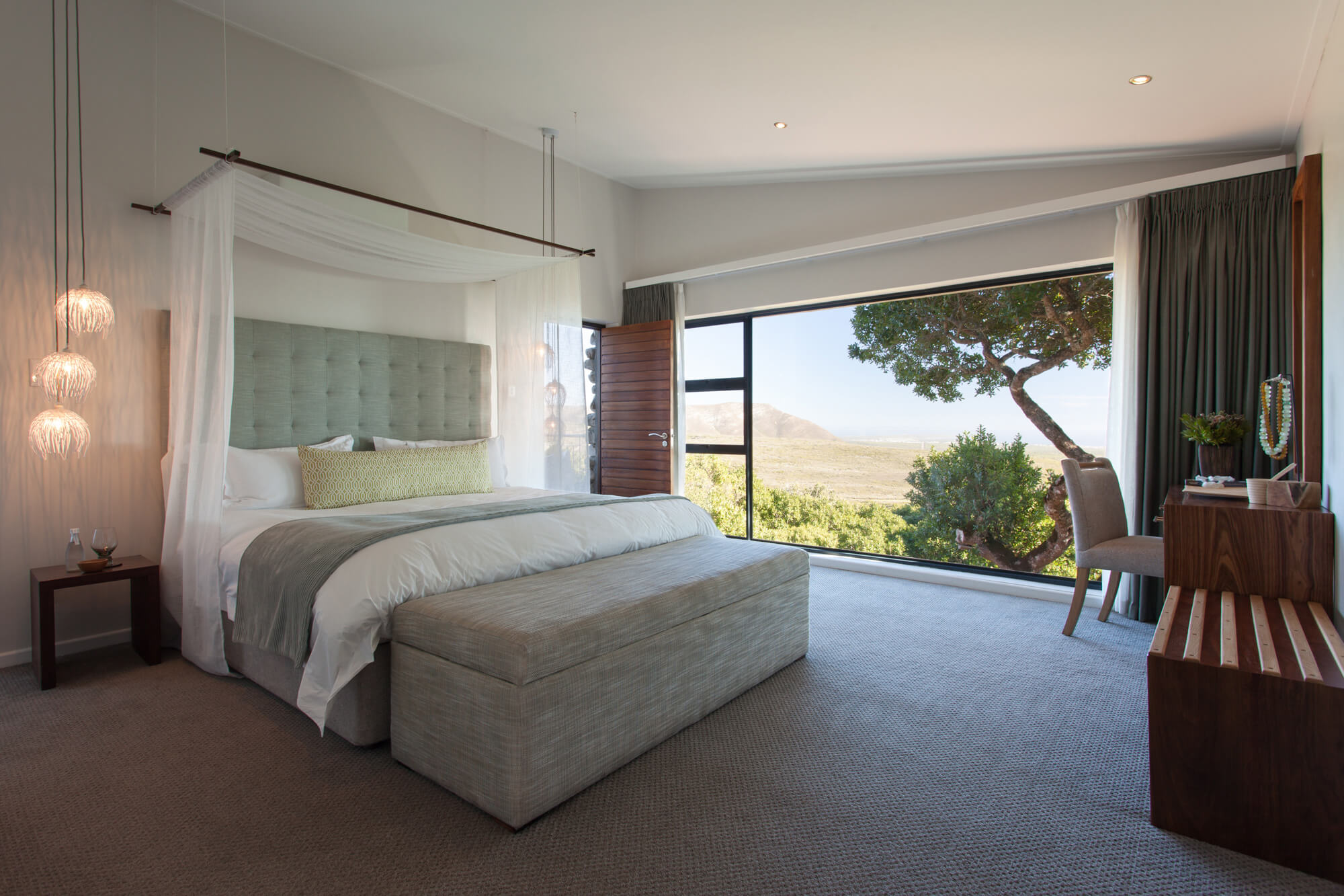 Elegante Suite mit Kingsize-Bett und Blick in die Natur.