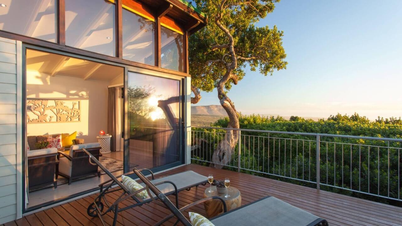 Balkon einer Suite mit zwei Liegen und Blick ins Grüne.