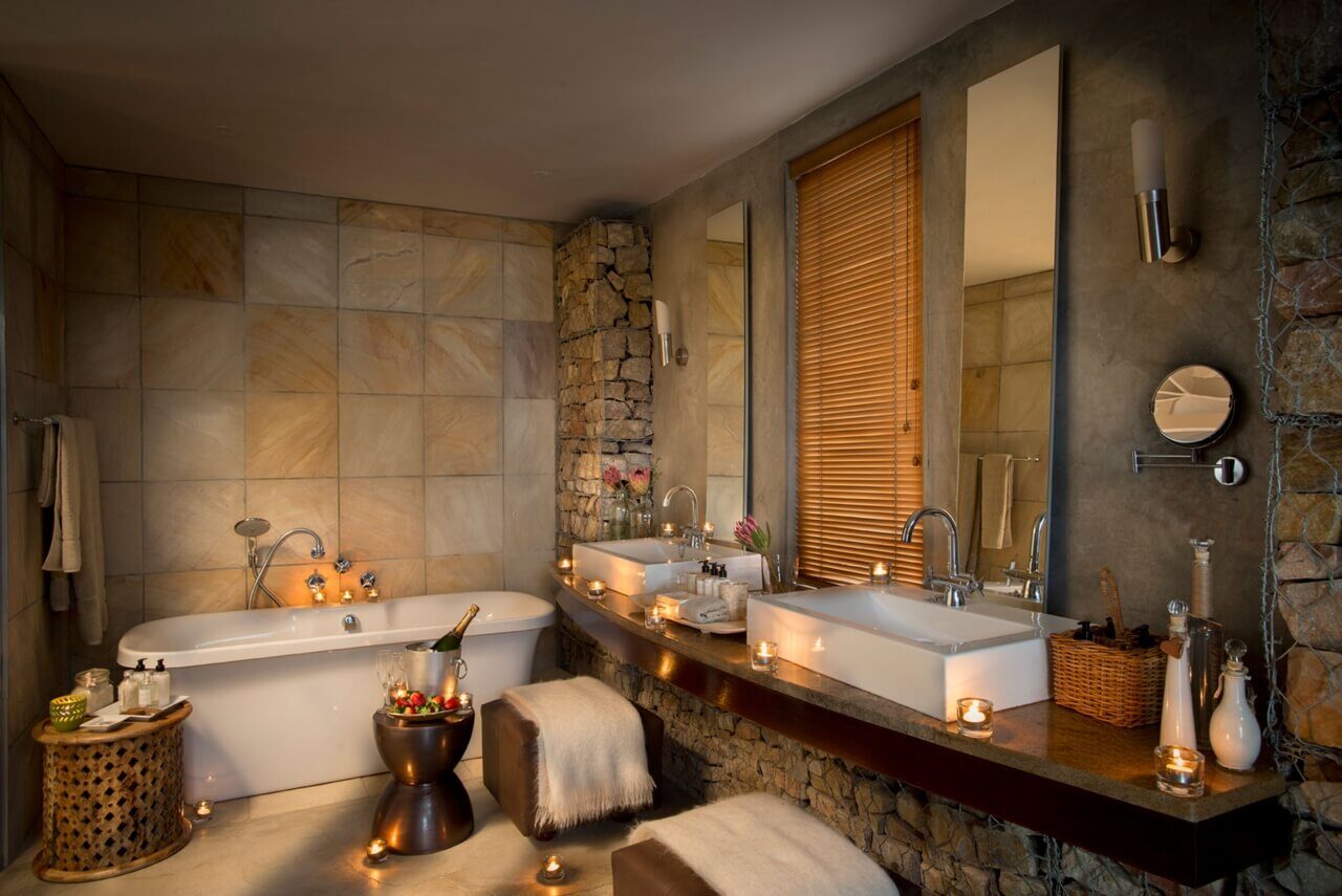 Elegantes Badezimmer mit zwei Waschbecken, beleuchtet mit Kerzen.