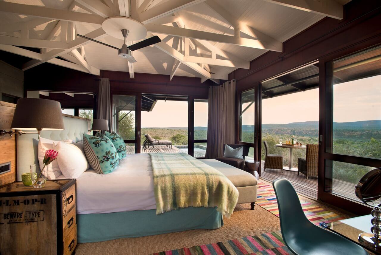 Suite mit Kingsize-Bett und großen Fensterfronten mit freiem Blick in die Natur.