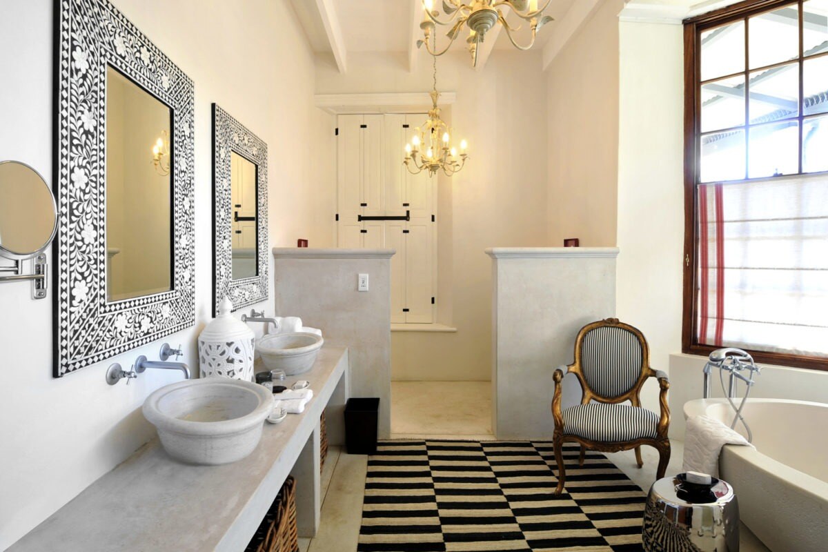 Badezimmer mit zwei freistehenden Waschbecken und zwei opulenten Spiegeln.