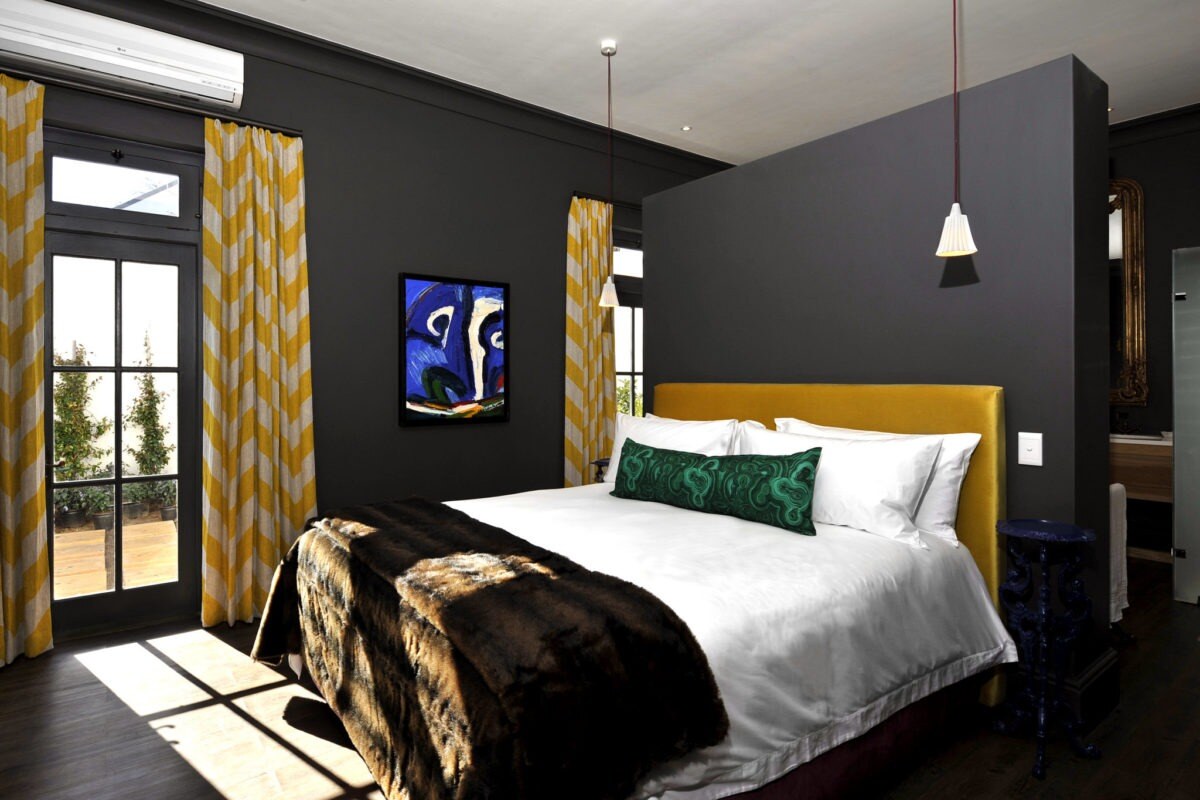 Kingsize-Bett mit schwarzem Raumtrenner.