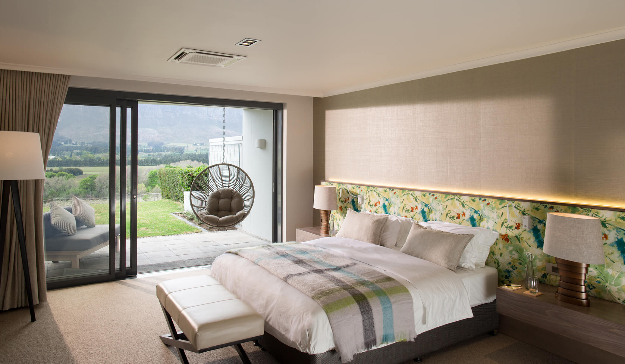 Hotelzimmer mit weißem Kingsize-Bett und Balkon.