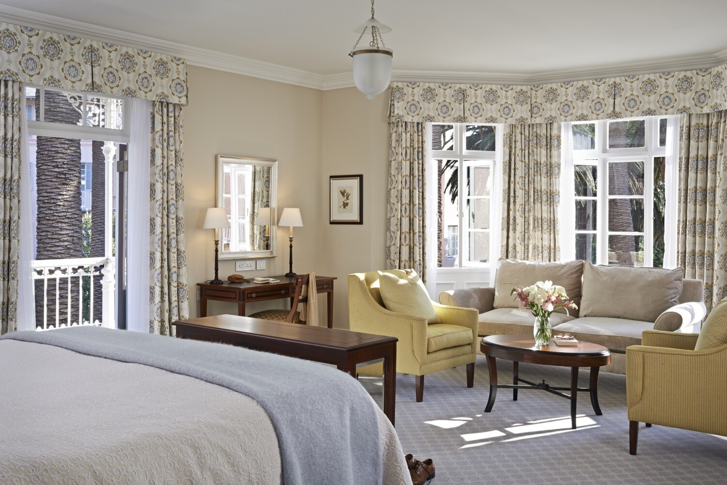 Stilvolle Suite mit Kingsize-Bett, Sitzecke und Tisch.