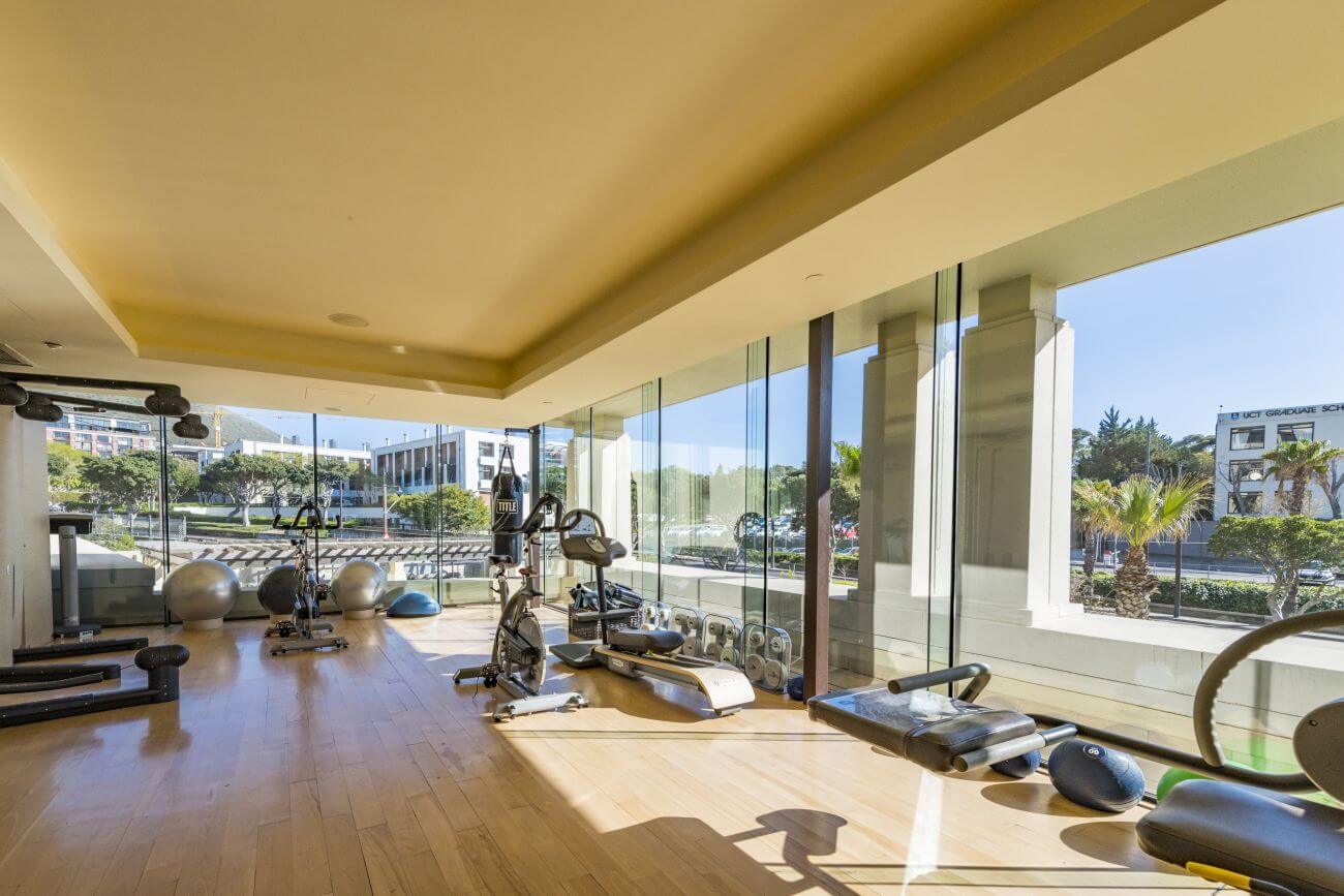 Fitnesscenter mit verschiedenen Geräten und Blick auf Kapstadt.