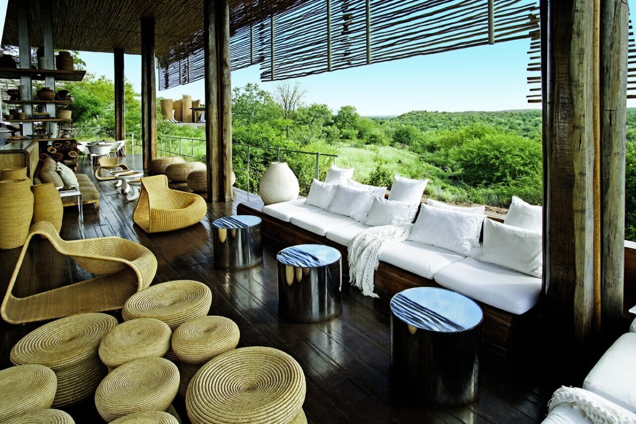Lounge mit Sitzecke am Fenster und Aussicht in die Natur.