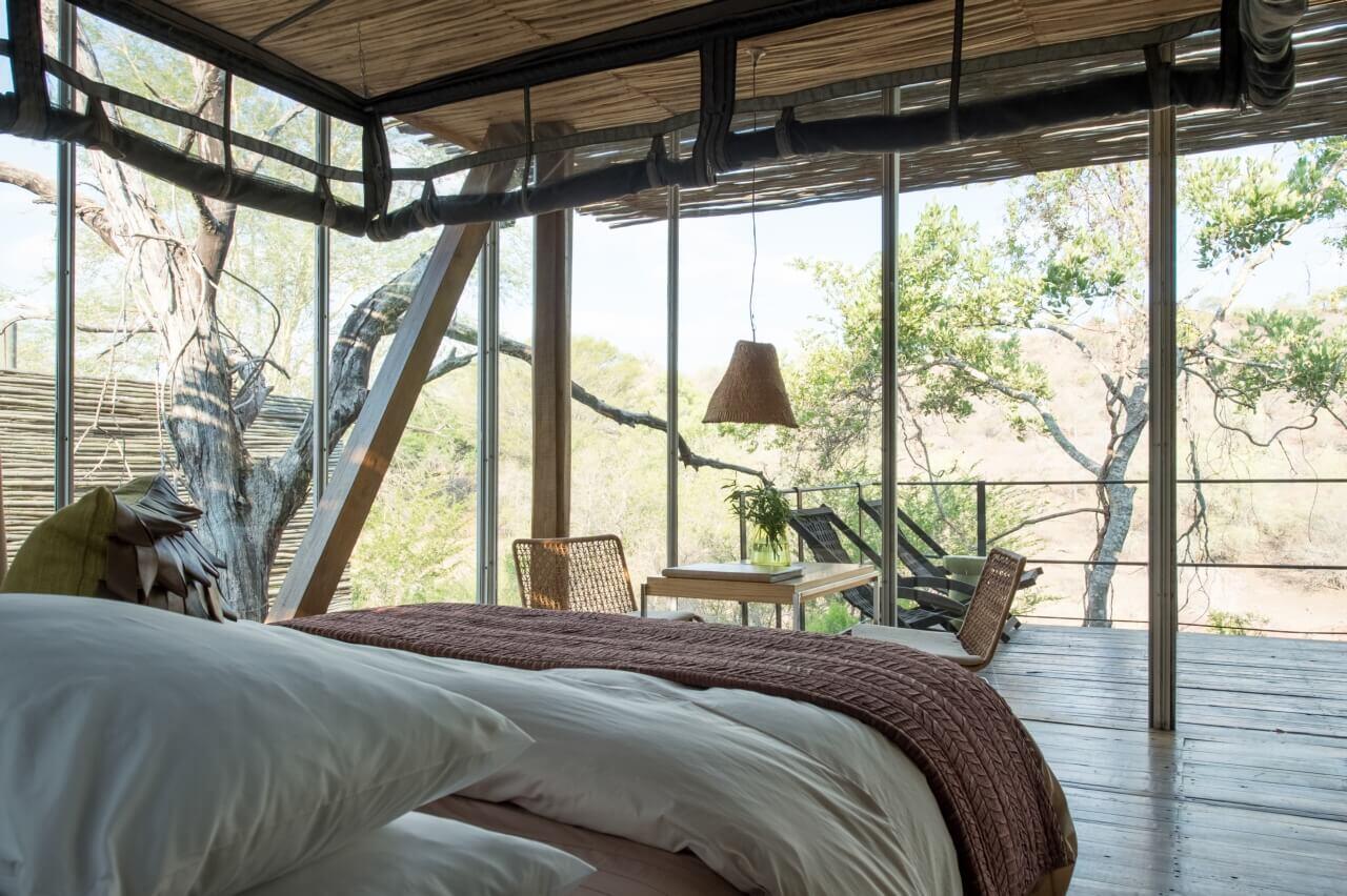 Helle Suite mit raumhohen Fenster und viel Natur drumherum.