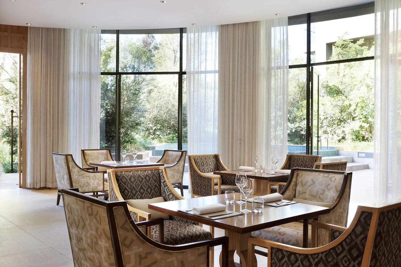 Esstisch in einem edlen Restaurant mit bodenlangen Vorhängen.