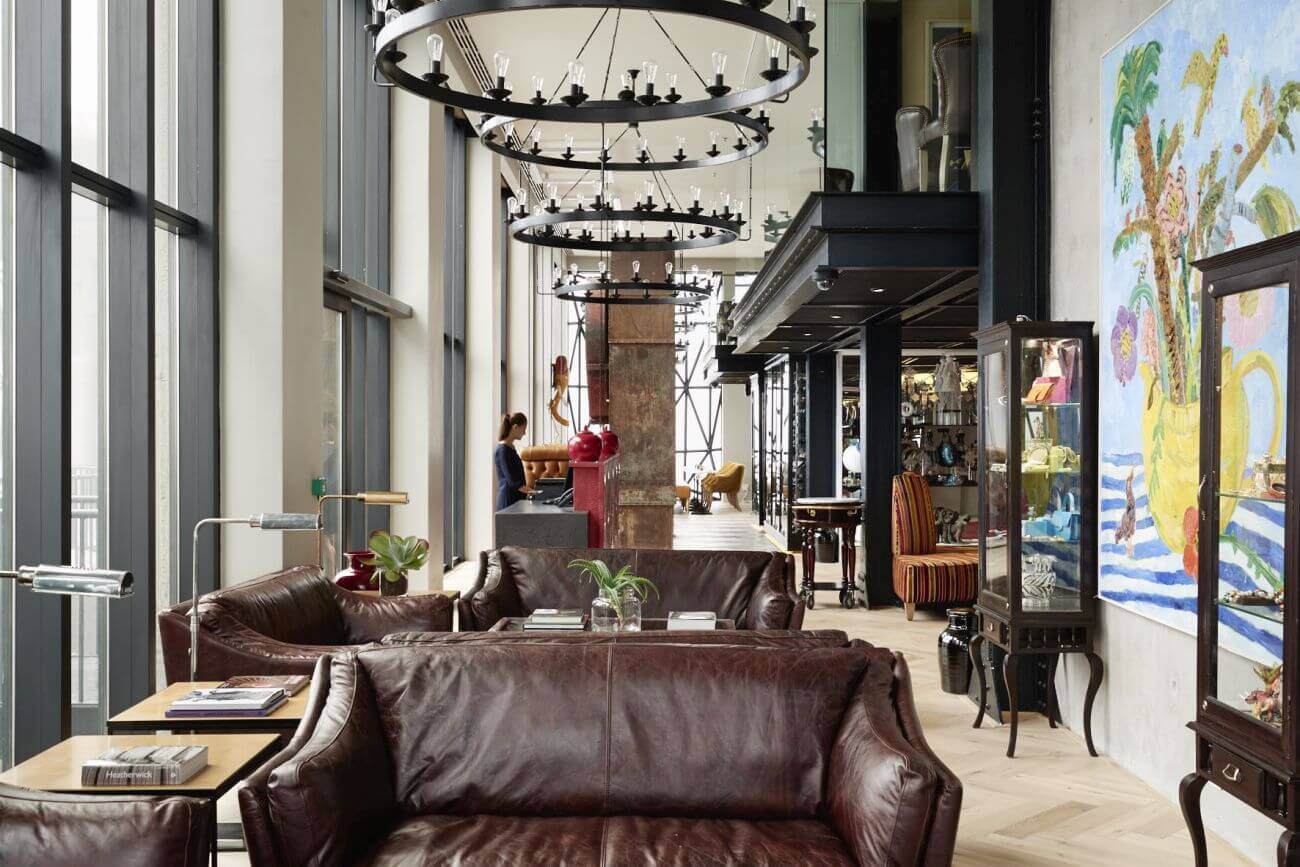 Café mit Ledersofas und Kronleuchtern an der Decke.