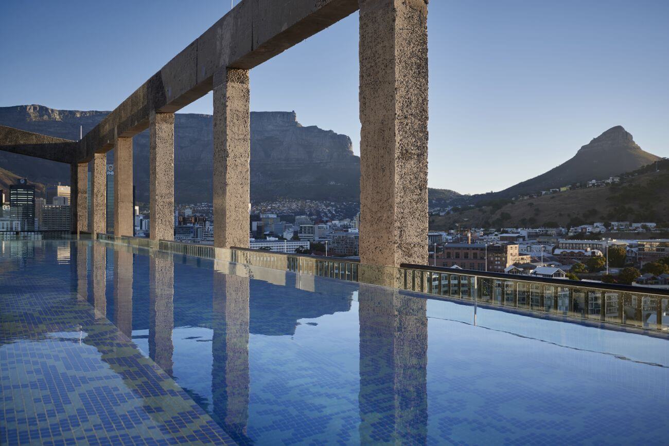 Pool auf einer Dachterrasse mit Steinsäulen.