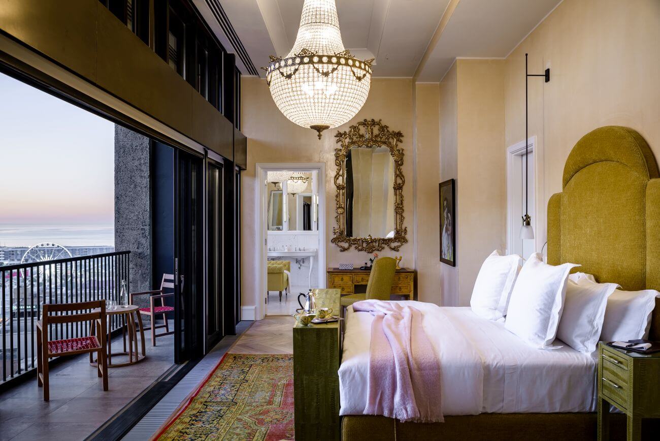 Suite mit Balkon, Kronleuchtern, antikem Spiegel und Kingsize-Bett.