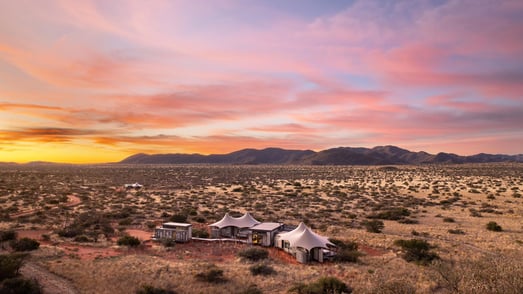 Zeltcamp in der Kalahari aus der Vogelperspektive bei Sonnenuntergang.