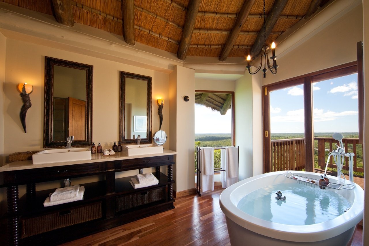 Badezimmer mit zwei Spiegel, zwei Waschbecken und einer freistehenden Badewanne.