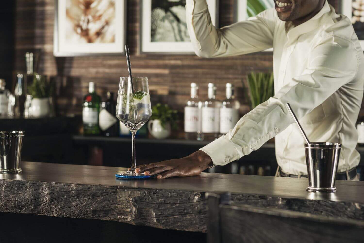 Ein Barkeeper schenkt einen Wein am Tresen aus.