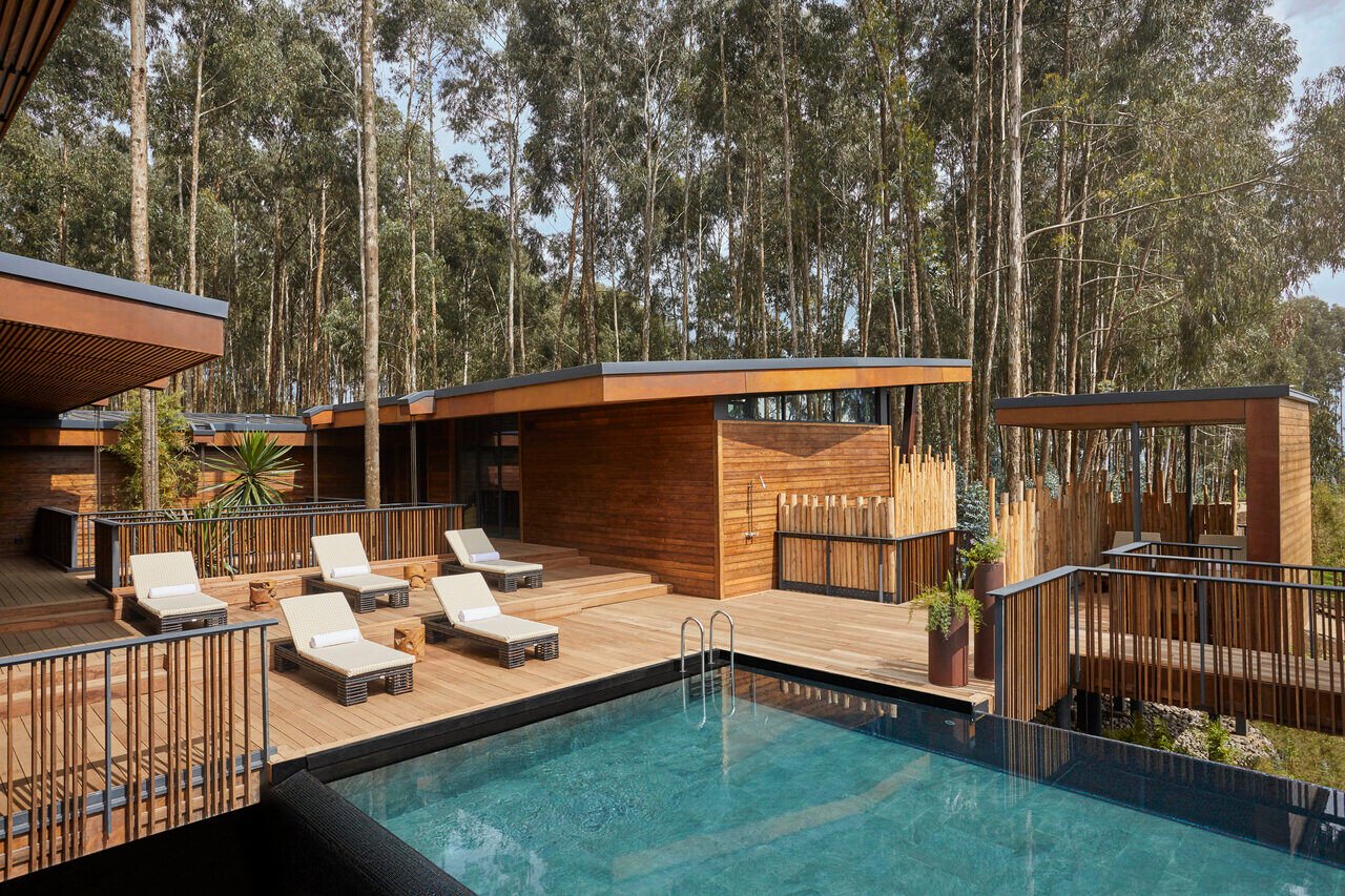 Pool mit Holz-Sonnendeck und fünf Sonnenliegen.