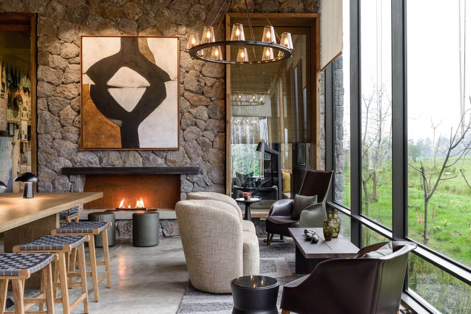 Lounge mit gemütlichen Sesseln und einem Kaminfeuer.