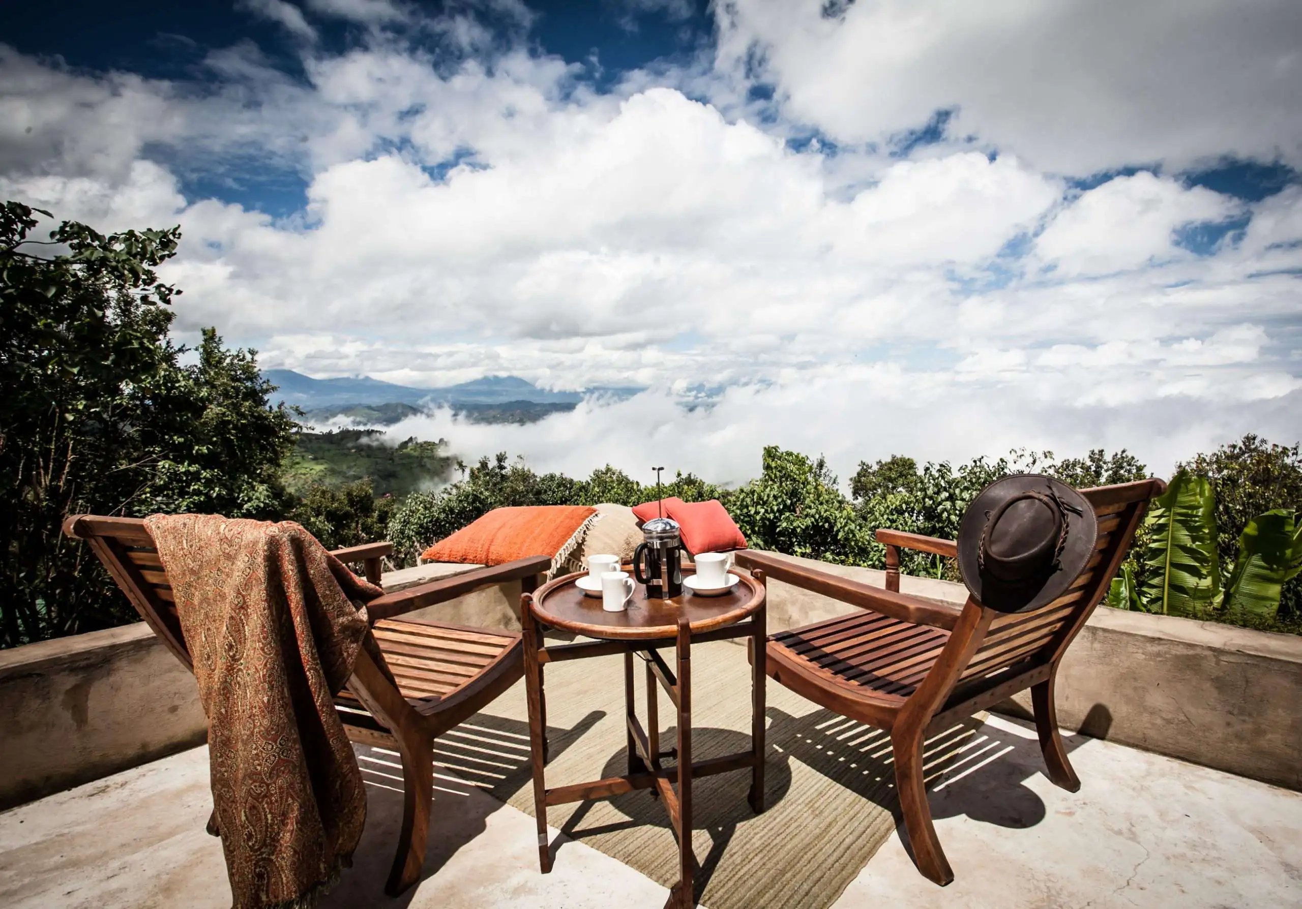 Balkon mit zwei Stühlen und Tisch mit Aussicht in ein Tal.