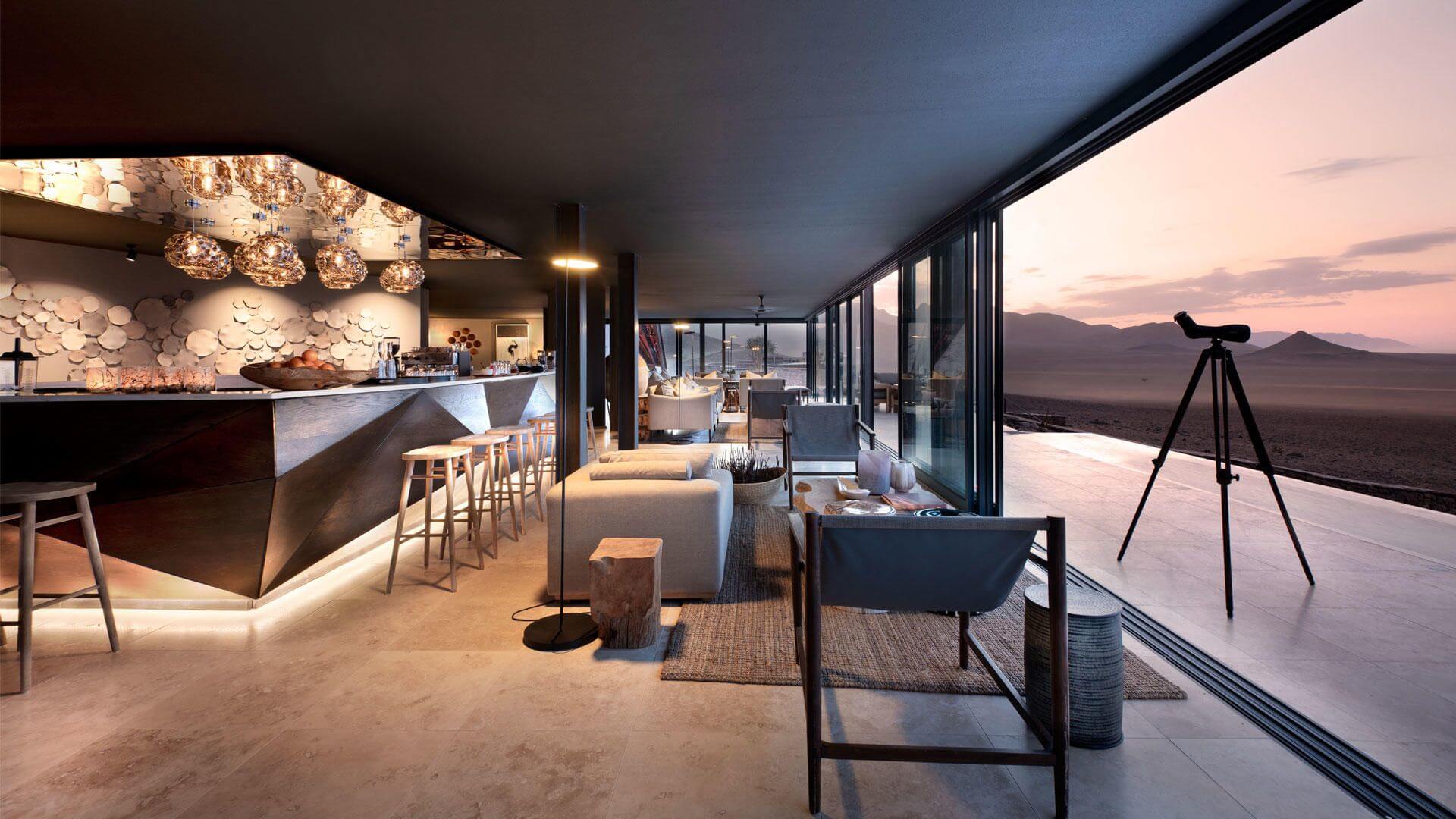 Bar mit Loungemöbeln und einer Terrasse, auf der ein Teleskop steht.