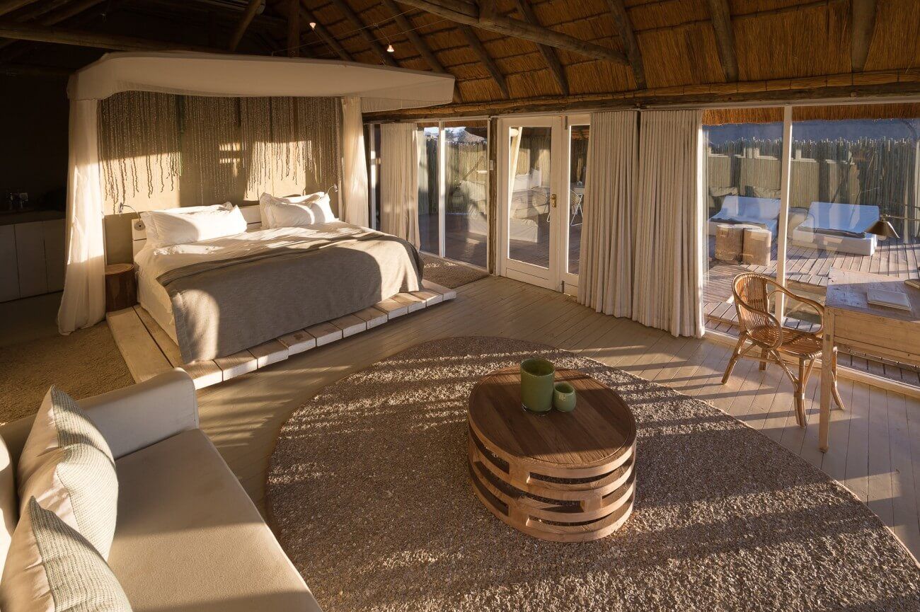 Luxuriöse Lodge mit Teppich, Kingsize-Bett und Sofa, alles in hellen Farben gehalten.