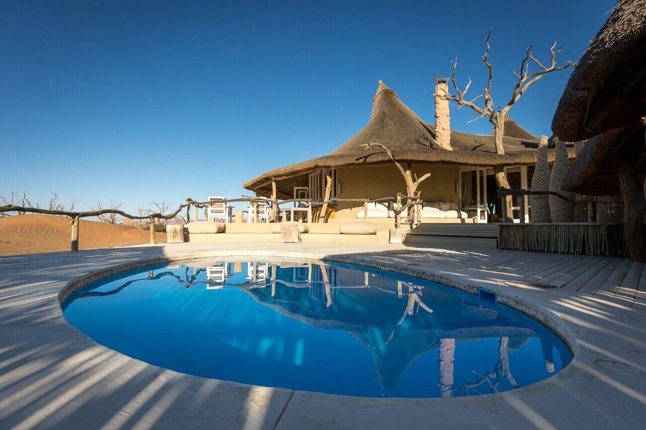 Runder Pool einer Lodge, die sich im Hintergrund befindet.