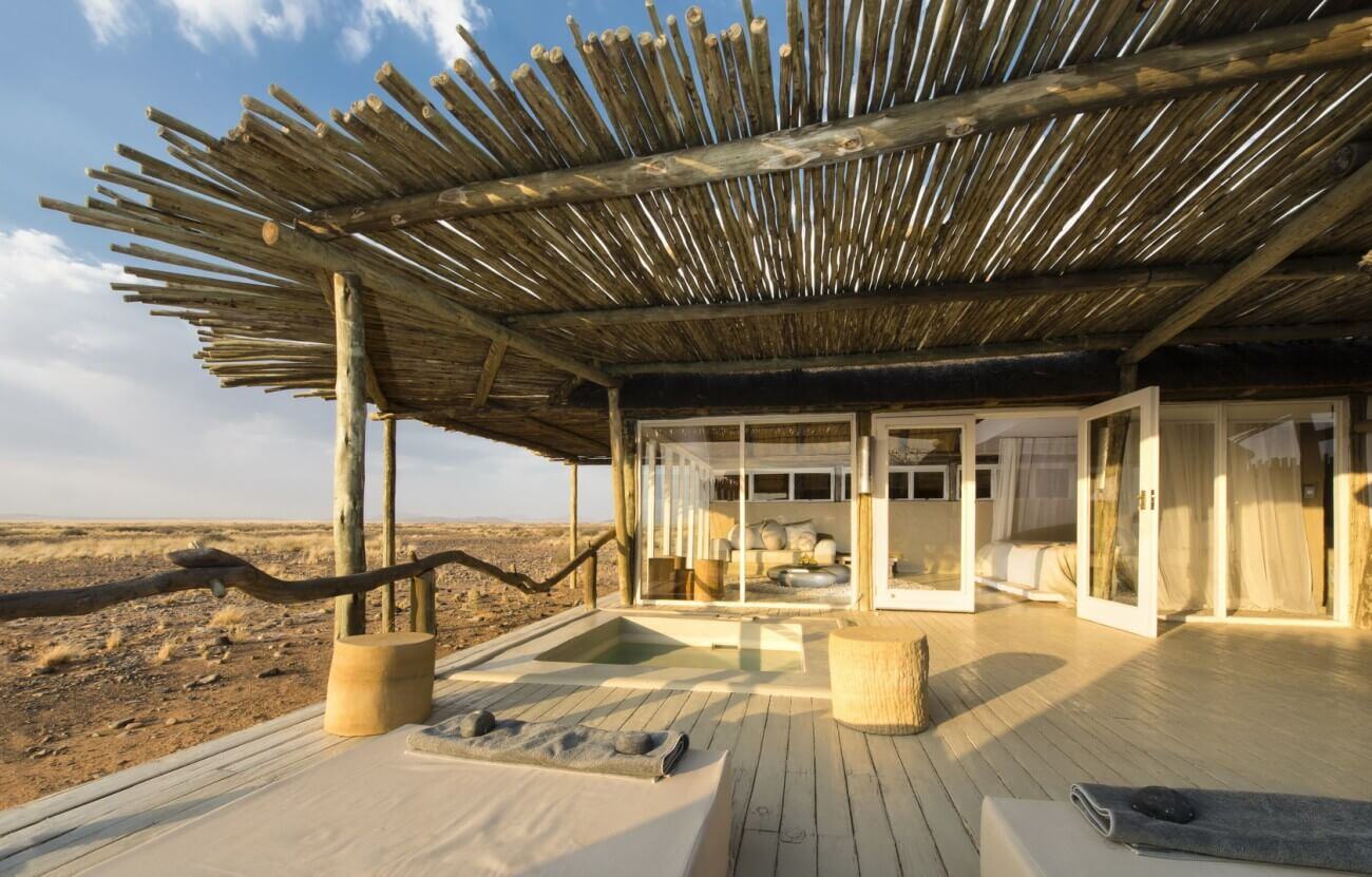 Großzügig geschnittene Terrasse einer Lodge mit Blick in die Wüste.