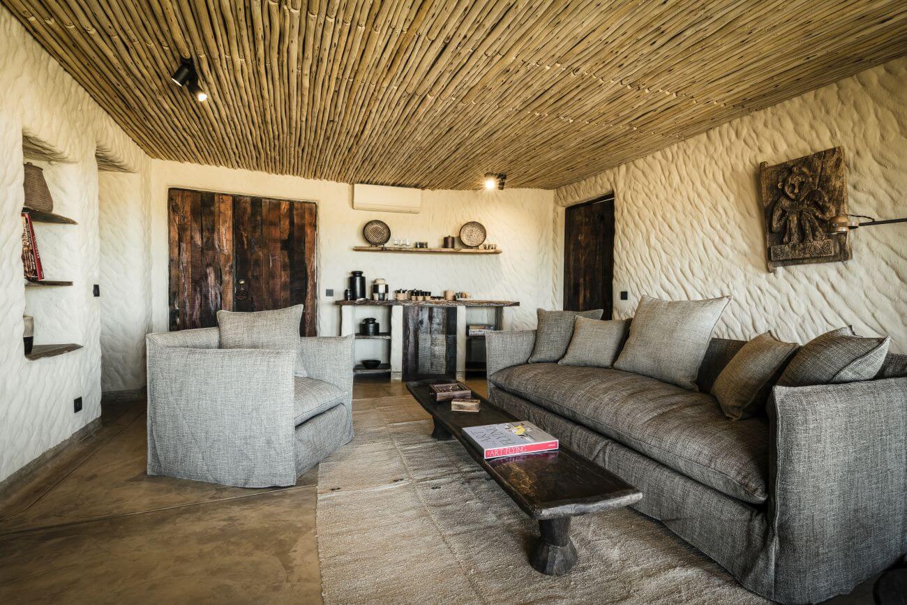 Luxuröses Wohnzimmer mit großen Sofas und Sesseln in natürlichen Farben.