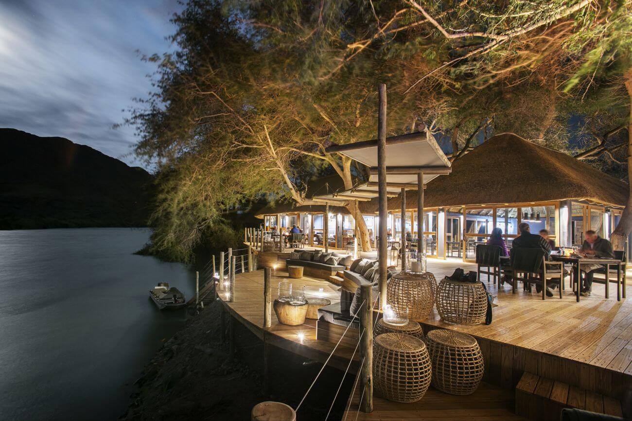 Restaurant am Fluss bei Abendlicht.