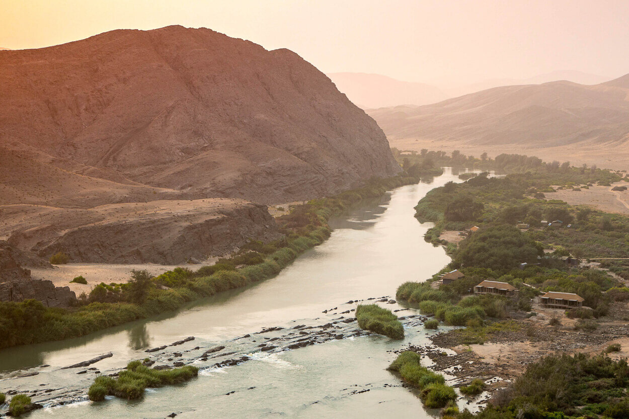Serra Cafema Camp in Namibia am Ufer des Kunene River vor atemberaubender Bergkulisse