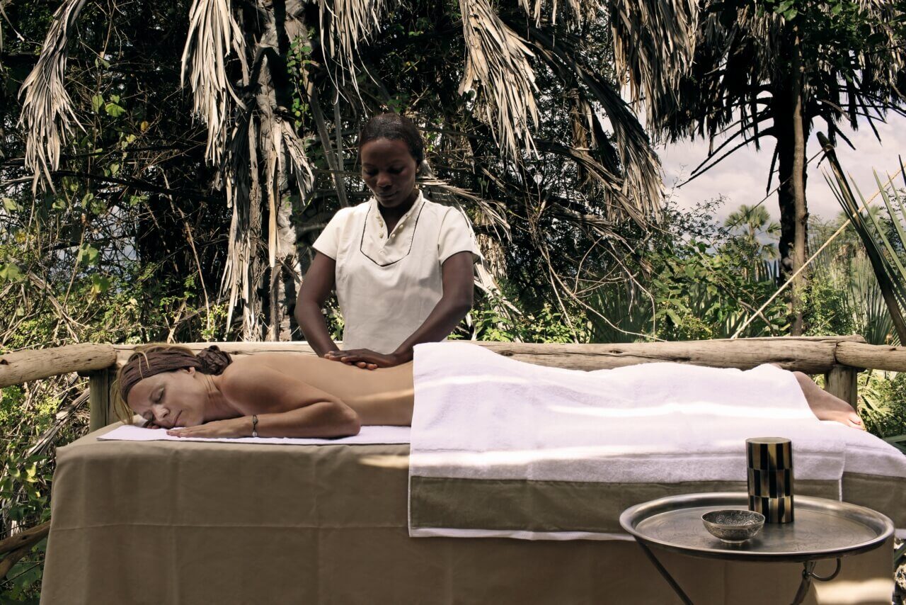 Eine Frau erhält auf einer Liege im Freien eine Massage.