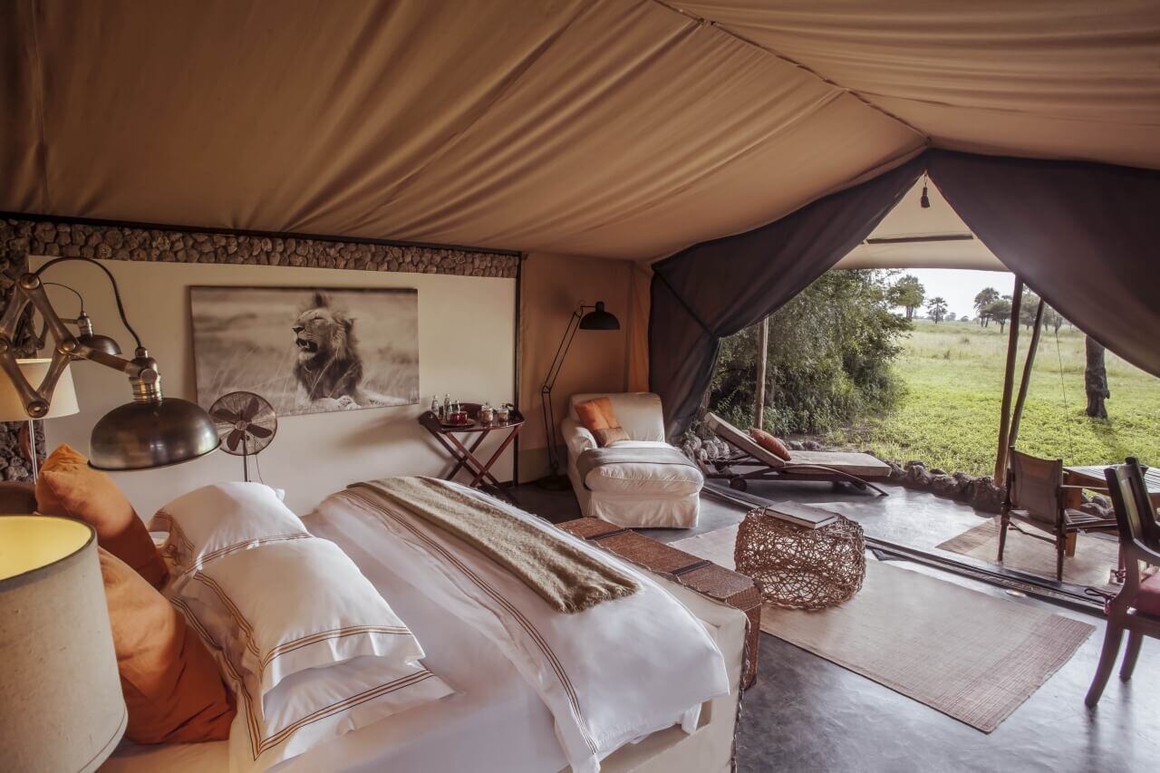 Großes Safari-Luxuszelt mit Kingsize-Bett und Blick in die Natur.