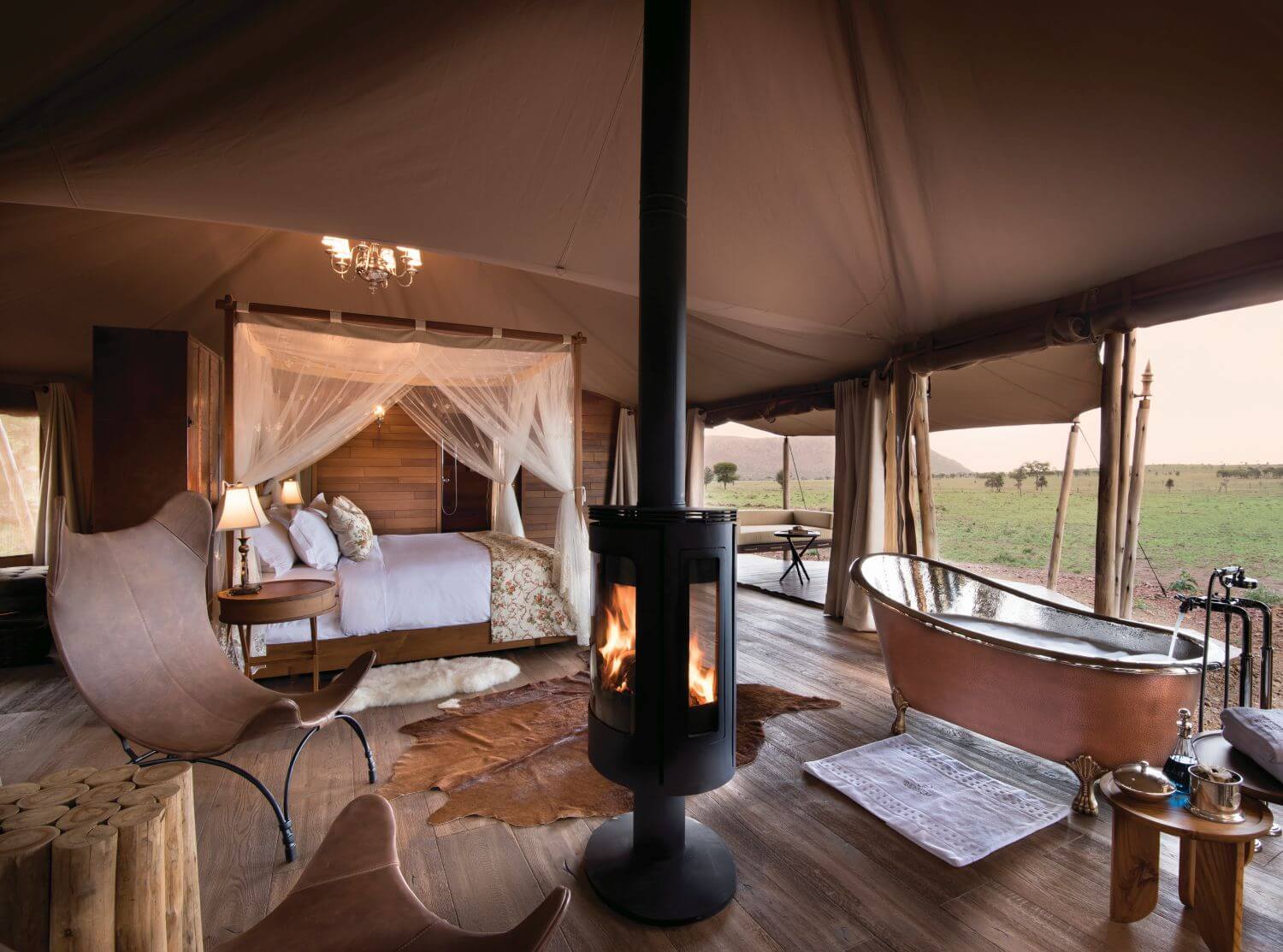 Geräumiges Safarizelt mit Kingsize-Bett, Badewanne, Ofen und Blick in die Savanne.