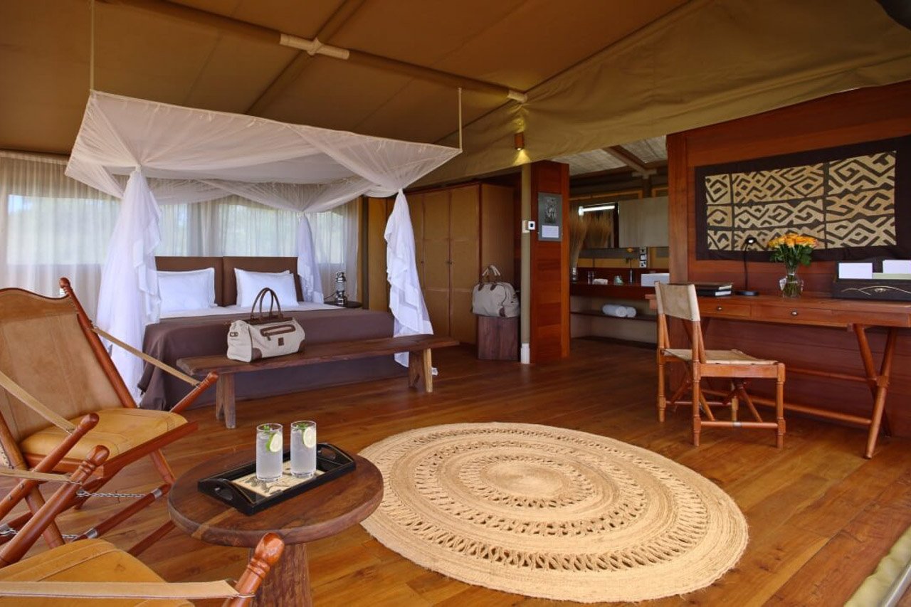 Suite in einer Lodge mit Kingsize-Bett und klassischer Safari-Einrichtung.