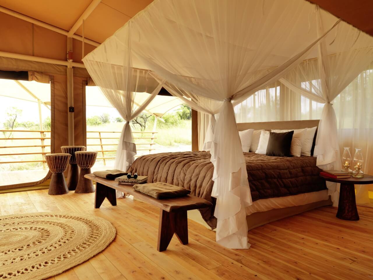 Suite mit Himmelbett und rundem Teppich davor.