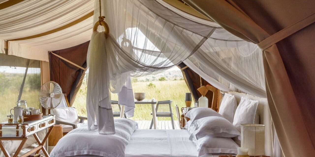 Luxuszelt mit Kingsize-Bett in hellen Farben gehalten.