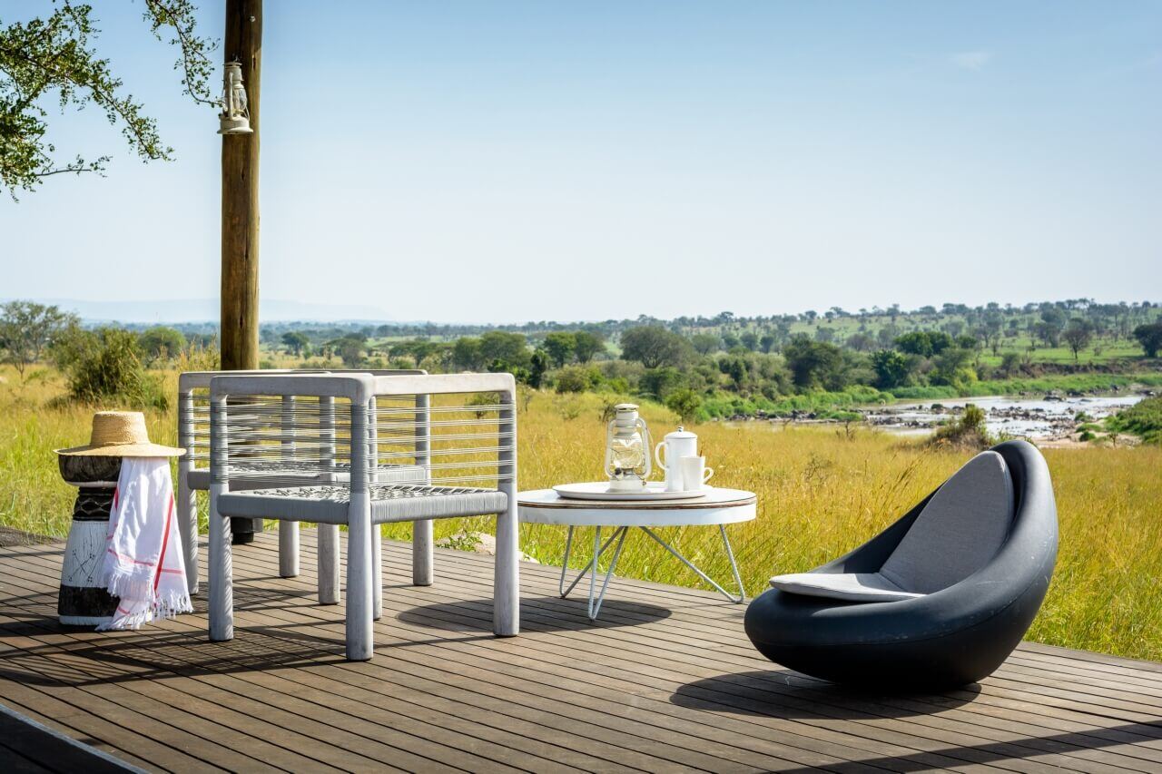 Terrasse im Grünen mit Stühlen und kleinem Tisch.