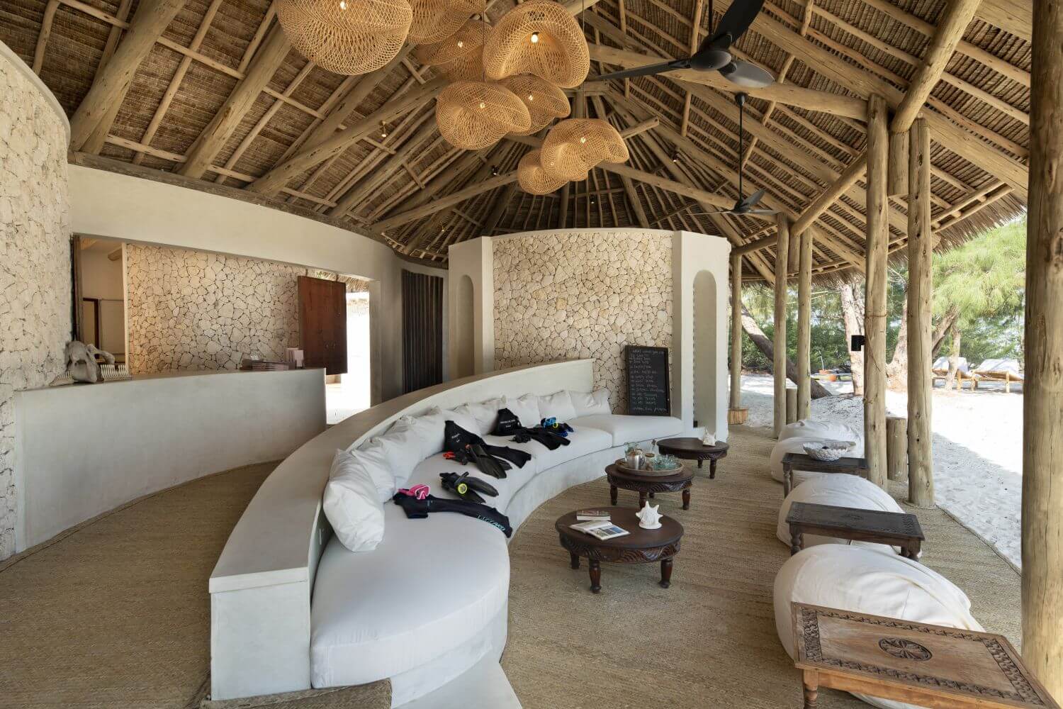 In einer Lodge steht ein großes, halbrundes Sofa, darauf liegen Tauchutensilien.