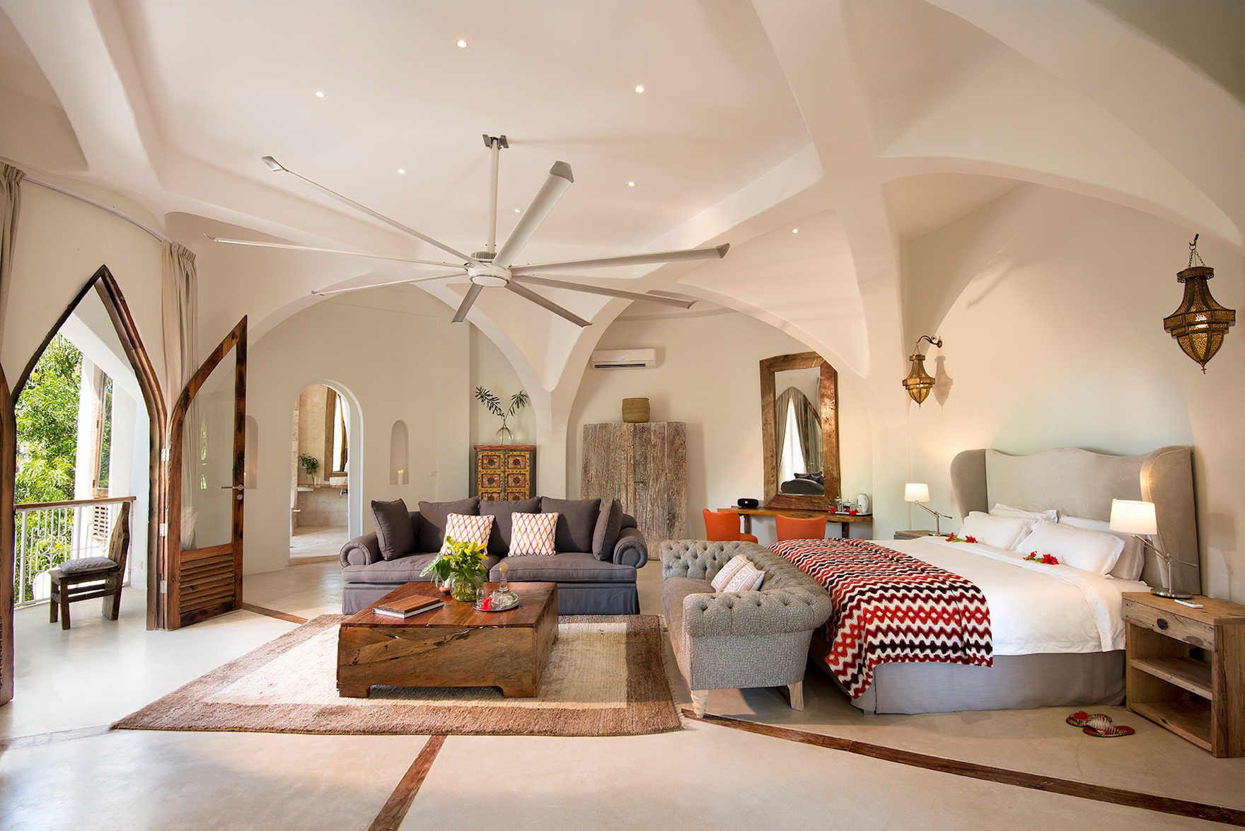 Großzügiger Wohnraum einer Luxusvilla mit Kingsize-Bett und Siztmöbeln.