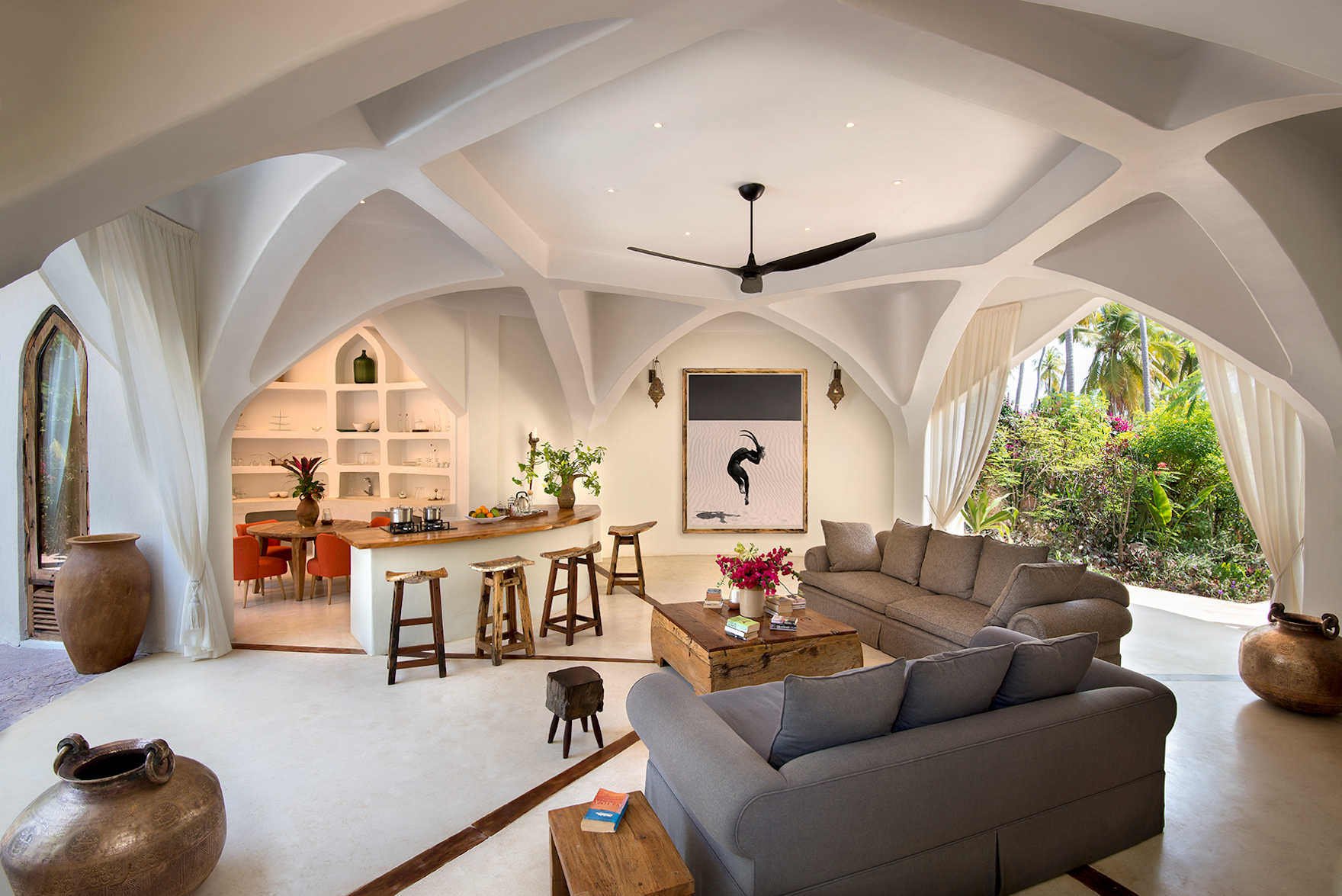 Wohnbereich einer Luxusvilla mit großem Sofa und einem Tresen im Hintergrund.